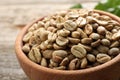 Green coffee beans in wooden bowl on table, closeup Royalty Free Stock Photo