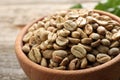 Green coffee beans in wooden bowl on table, closeup Royalty Free Stock Photo