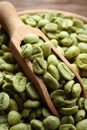 Green coffee beans and wooden scoop in bowl, closeup Royalty Free Stock Photo