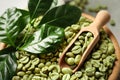 Green coffee beans, wooden scoop and leaves in bowl, closeup Royalty Free Stock Photo