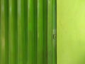 Green color harmonica door and house wall, suitable for background of your project