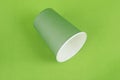 Green color paper drink glass disposable on green background