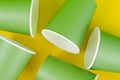 Green color paper drink glass disposable on yellow background