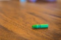 Green color pastel crayon on brown wooden table Royalty Free Stock Photo