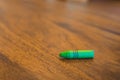 Green color pastel crayon on brown wooden table Royalty Free Stock Photo