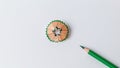 Green color pencil and a colorful pencil shavings on a white background. Royalty Free Stock Photo