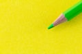 Green color pencil on yellow color paper arranged diagonally Royalty Free Stock Photo