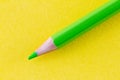 Green color pencil on yellow color paper arranged diagonally Royalty Free Stock Photo