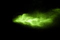 Green color powder explosion cloud on black background.Green dust splash on dark background