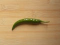Green color raw whole Chili pepper on wood