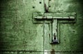 Green color rusty door close up detail with padlock and bolt Royalty Free Stock Photo