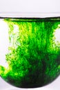 Green color spread in glass of water