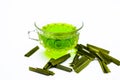 Green colored tea of lemon grass in a transparent cup isolated on white used in many ayurvedic treatments.