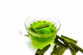 Green colored tea of lemon grass in a transparent cup isolated on white used in many ayurvedic treatments.