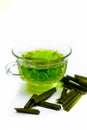 Green colored tea of lemon grass in a transparent cup isolated on white used in many ayurvedic treatments.