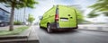 Green commercial van driving in the city Royalty Free Stock Photo