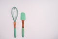 Green cooking whisk and a spatula isolated on a white background