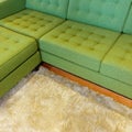 Green corner sofa on fluffy rug Royalty Free Stock Photo