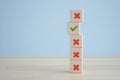Green correct check mark among many red wrong or cross icon on wooden stack for true or false. Royalty Free Stock Photo