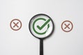 Green correct sign symbol inside of magnifier glass and among red incorrect or cross sign for focus and concentrate document check