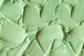 Green cosmetic clay cucumber facial mask, avocado face cream, green tea matcha body wrap texture close up, selective focus.