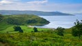 Green countryside surrounding Bay of Pledges beach and ocean