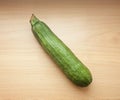 A green courgette or zucchini on a wooden table Royalty Free Stock Photo