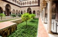 Green courtyard of Alcazar, example of Mudejar architecture of the 14th century, historical royal palace with trees