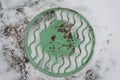The green cover of sewerage, covered with white snow. Royalty Free Stock Photo