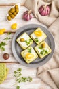 Green cracker sandwiches with cream cheese and cherry tomatoes on white wooden background. top view, close up