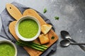 Green cream asparagus soup on a cutting board with toast, gray background. Top view, copy space, flat lay Royalty Free Stock Photo