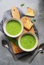 Green cream asparagus soup with toast on a cutting board, gray concrete background. Vegan Vegetarian Soup. Top view, flat lay Royalty Free Stock Photo