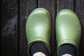 Green crocs clog worn by the man in black socks