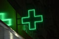 Green cross pharmacies at night in the city. Glowing with LED lamps, the green cross of the hospital Royalty Free Stock Photo