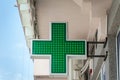 Green cross pharmacy sign or symbol on the building facade view from the street Royalty Free Stock Photo