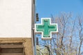 Green cross pharmacy sign or symbol on the building facade view from the street Royalty Free Stock Photo