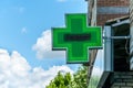 Green cross pharmacy sign or symbol on the building facade view from the street Royalty Free Stock Photo