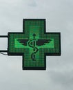 Green cross pharmacy store sign with caduceus. Pharmacy sign. Royalty Free Stock Photo