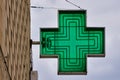 green cross-shaped pharmacy sign with sky in the background Royalty Free Stock Photo