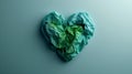 A green crumpled paper heart shape on a blue background Royalty Free Stock Photo