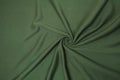 Green crumpled or wavy fabric texture background. Abstract linen cloth soft waves. Creases of satin, silk, and cotton Royalty Free Stock Photo
