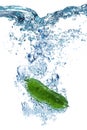 Green cucumber falls deeply under water