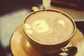 Green cup with cappuccino coffee close up. A cat and a heart are drawn on the foam. On a brown table is a mug with hot tasty Royalty Free Stock Photo