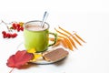 Green cup with coffee and milk on a white background decorated with autumn leaves. Two cookies on a plate. Royalty Free Stock Photo