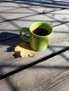 Green cup of hot tea with yellow leav Royalty Free Stock Photo