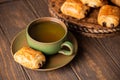 Green cup of tea with mini chocolate bun Royalty Free Stock Photo