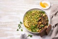 Green curry chickpea with baked eggplant, parsley and lemon on light wooden table