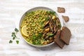 Green curry chickpea with baked eggplant, parsley and lemon on light wooden table