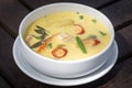 Green curry creamy soup with coconut milk, shrimp, red pepper, bean in white bowl, Thai cuisine Royalty Free Stock Photo