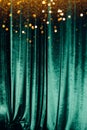 The green curtain made of luxurious velvet on the stage of the theater is fantastically glittering